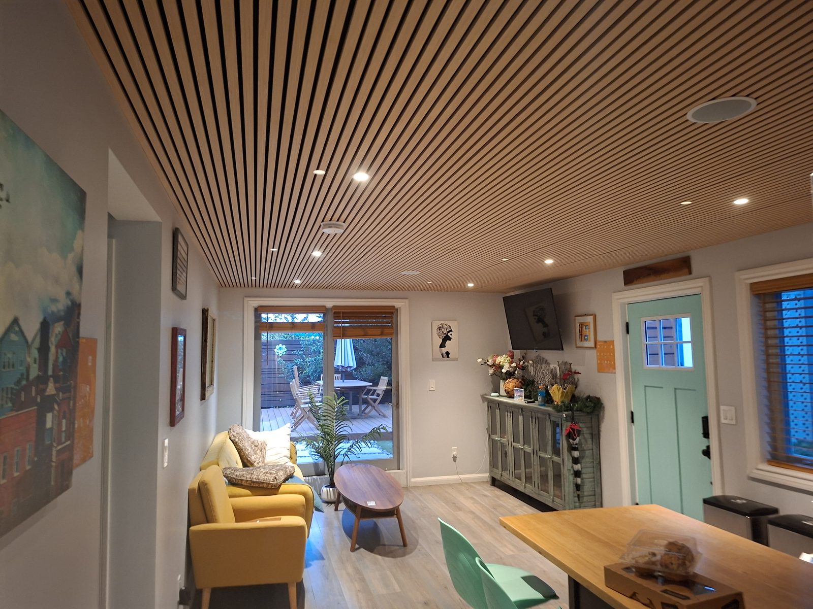 Open plan interior with custom wood slat ceiling, hardwood floors, and modern kitchen, full home remodel by Behan Builders