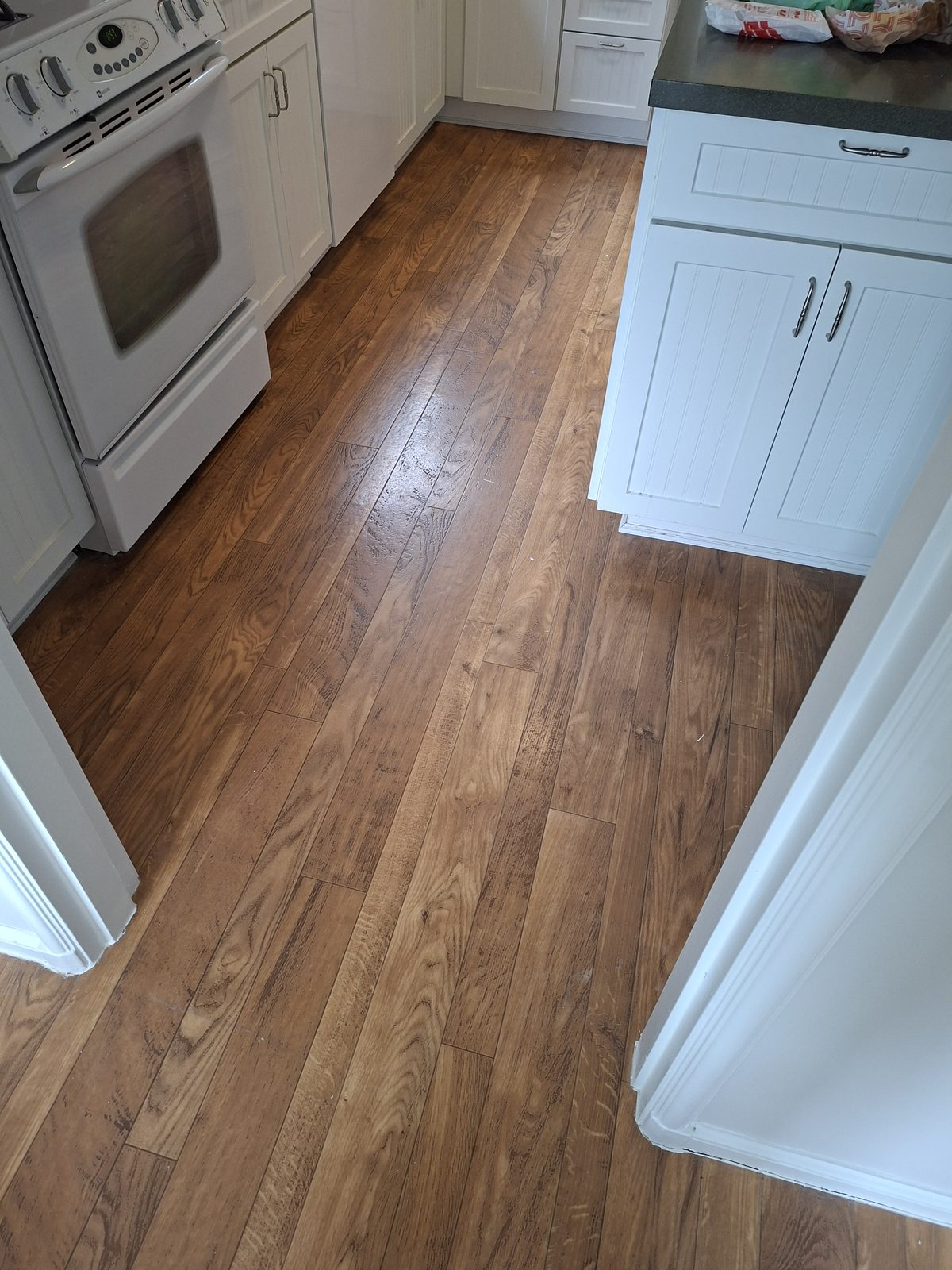 Updated kitchen with hardwood floors and white cabinetry in a Daly City home