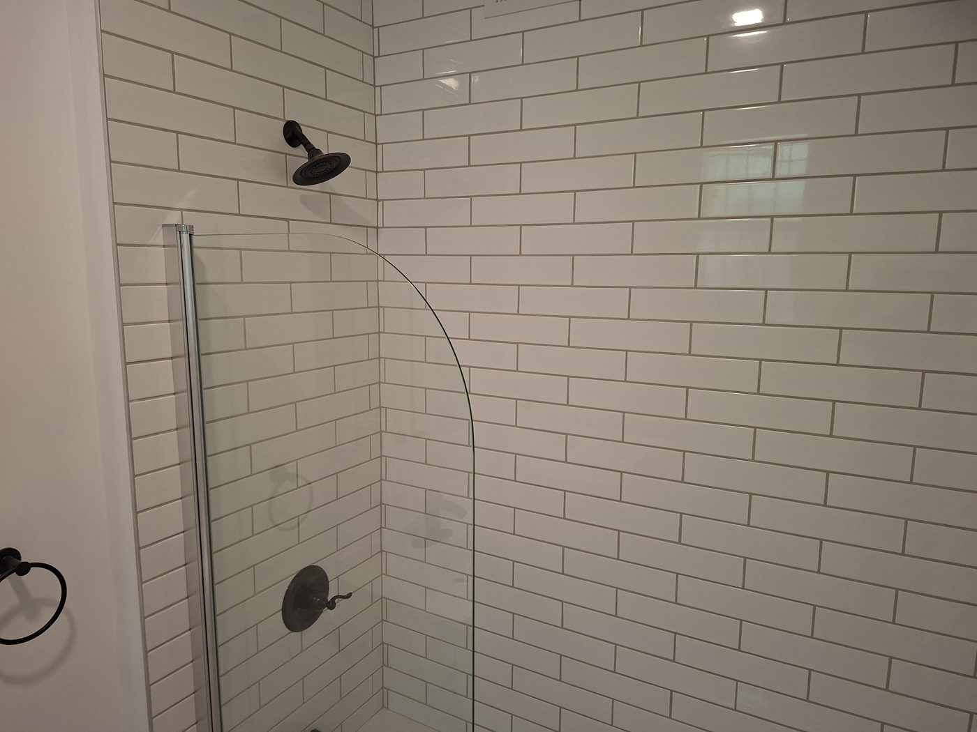 Bathroom remodel with white subway tile, frameless glass shower, and matte black fixtures