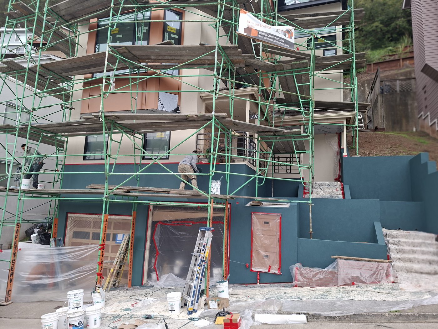 San Francisco home mid-project with fresh teal exterior paint and full scaffolding for proper prep work